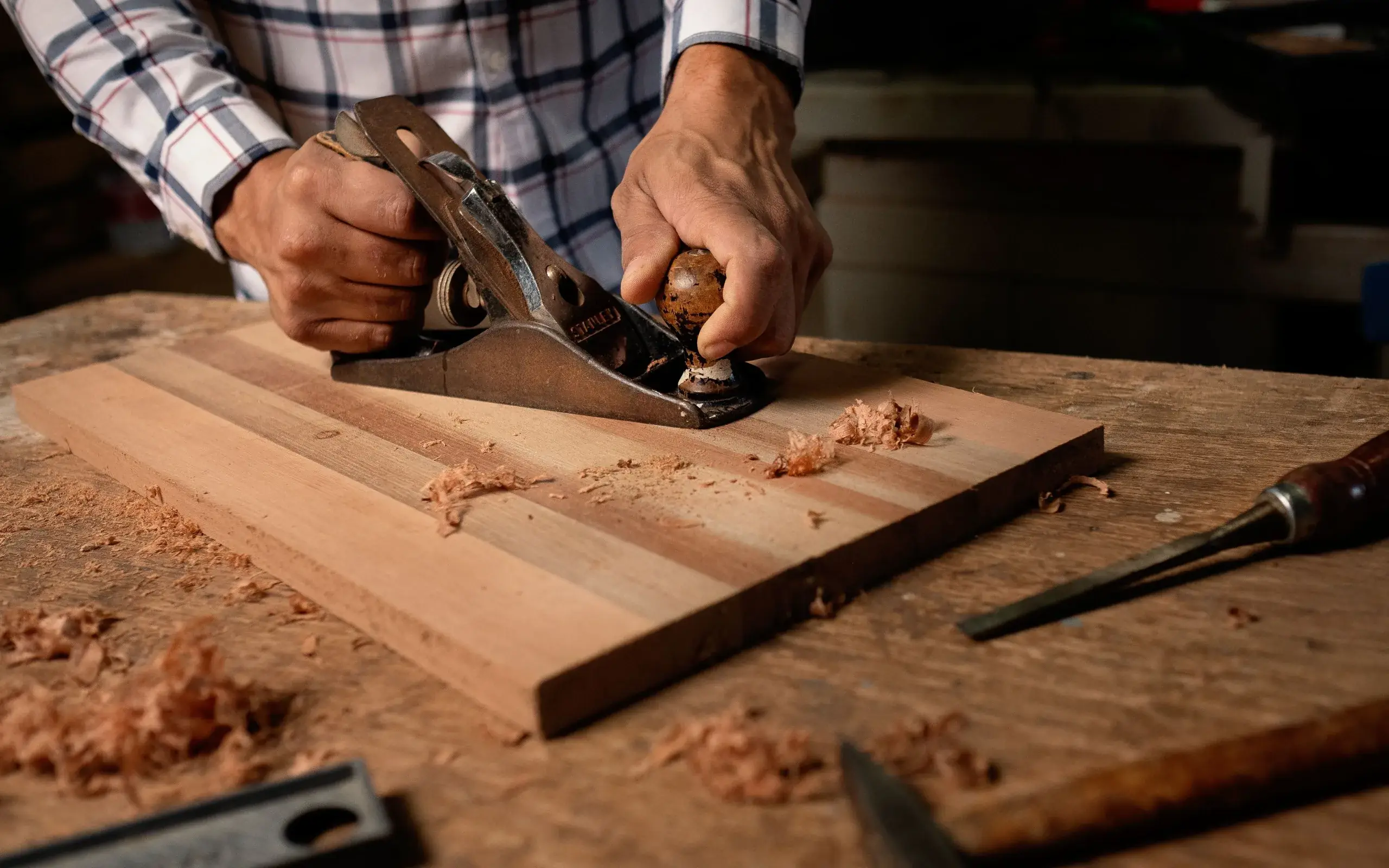 Artisan travaillant le bois à la main dans son atelier